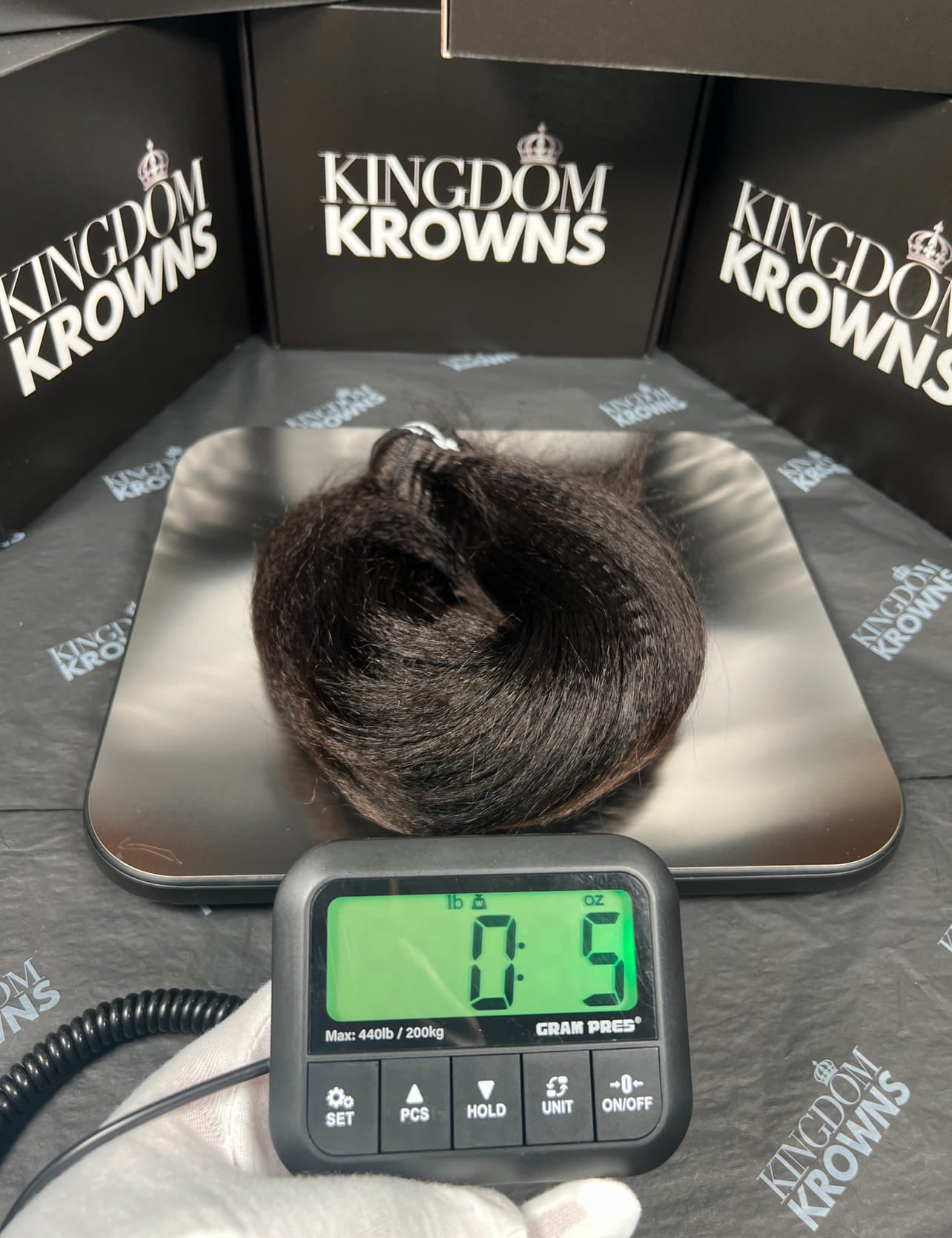 Hair on a scale with 'Kingdom Krowns' branding in the background