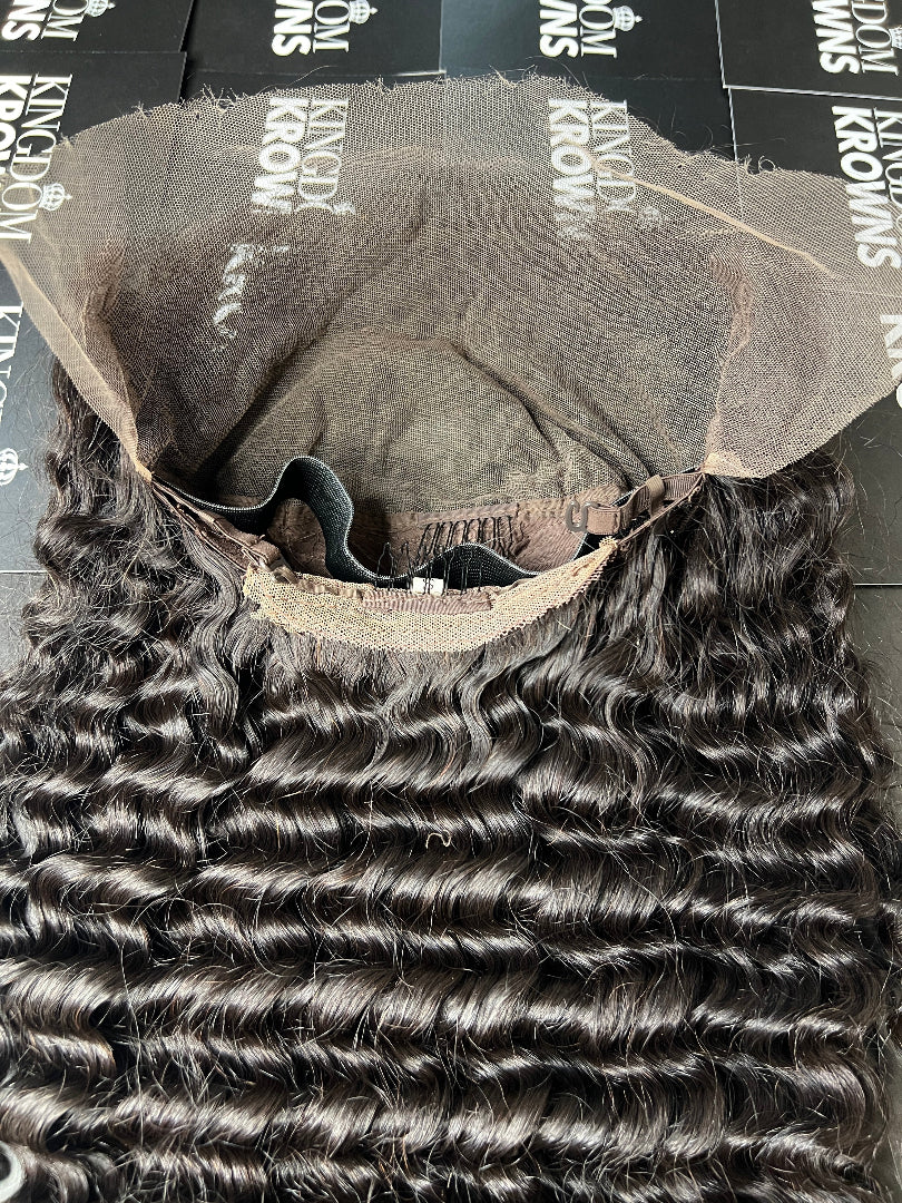A close-up image of a natural black lace human hair wig with deep wave texture.