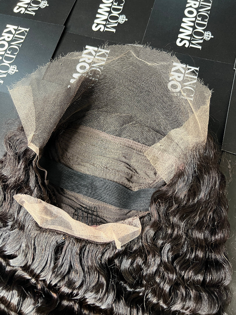 A close-up image of a natural black lace human hair wig with deep wave texture.