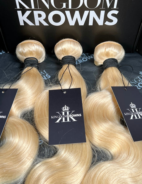 Blonde hair extensions with 'Kingdom Krowns' branding on tags.
