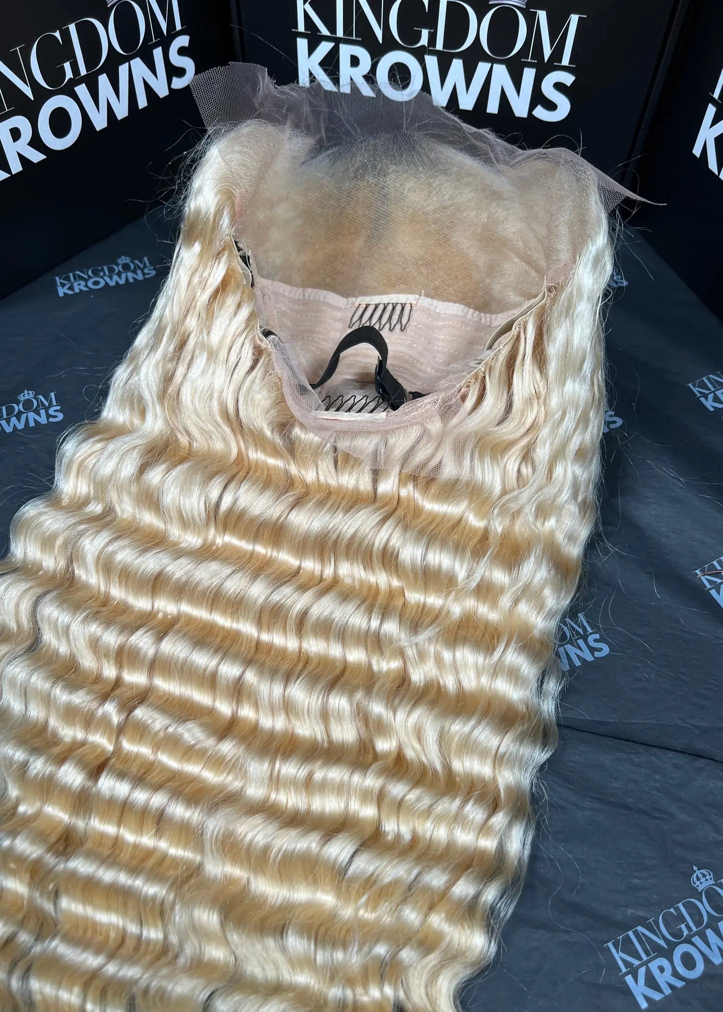 Blonde hair extensions on a black surface with 'Kingdom Krowns' branding.