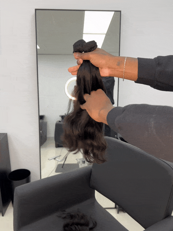 Black human hair extensions with loose curls on a white background