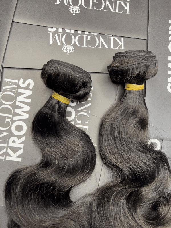 Black human hair extensions with loose curls on a white background