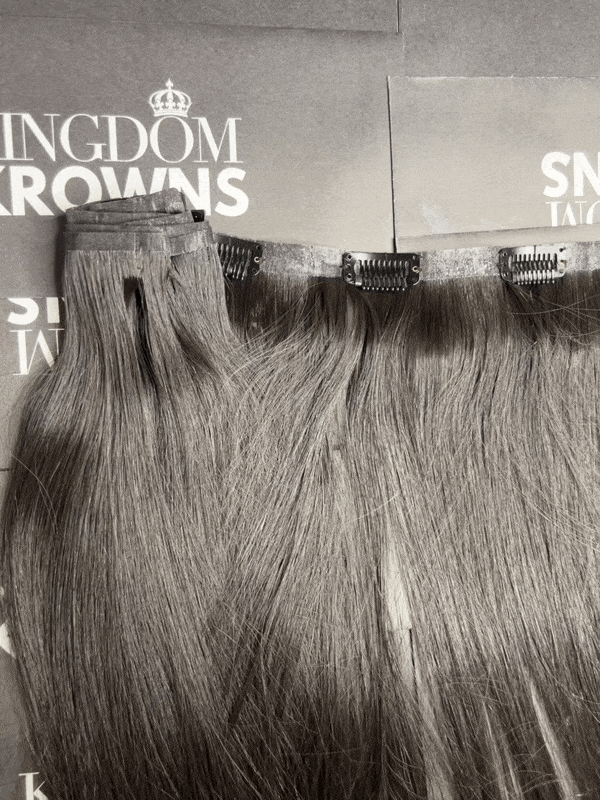 A set of clip-in human hair extensions in natural black color, displayed in a straight arrangement.